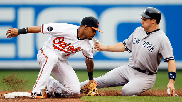 Robert Andino unsuccessfully attempts to tag out Mark Teixeira  