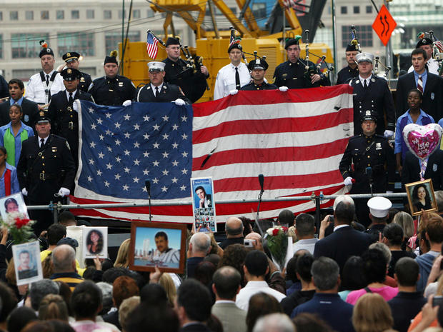 Participants of a 9/11 memorial ceremony view at Zuccotti Park Sept. 11, 2008, in New York City a tattered flag saved from the World Trade Center site. 