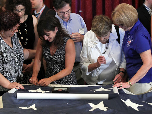 Family members of 9/11 victims participate in a flag-stitching event July 14, 2011, on Capitol Hill in Washington. About 150 people, including survivors, victims' loved ones, rescue and recovery workers and politicians, gathered to help repair the Nationa 