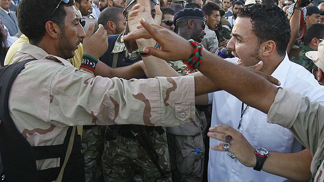 In this photo taken Sept. 10, 2011, Libya security argue during the arrival of Libyan Transitional National Council chairman Mustafa Abdel Jalil at Metiga airport in Tripoli, Libya .  