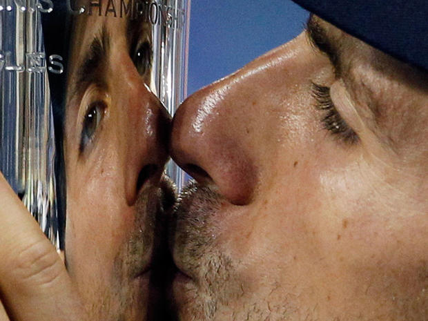 Novak Djokovic kisses the trophy after winning the men's championship 
