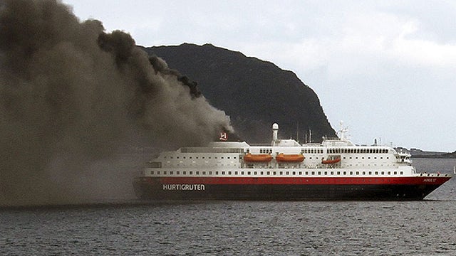 Norwegian cruise ship, MS Nordlys, one of the Hurtigruten ships billows smoke as it approaches Alesund in western Norway, Sept. 15, 2011.  