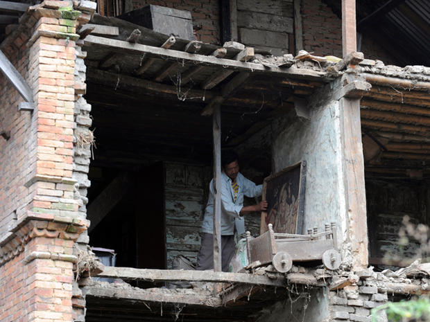 A Nepalese resident clears debris  