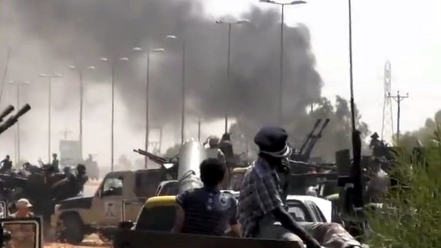 Libyan revolutionary fighters carry out an offensive against loyalist troops in the Qaddafi stronghold of Sirte, Libya. 