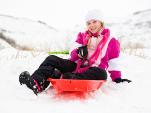 12/23/11 - A Guide To Twin Cities' Sledding Hills – girl in pink jacket on red sled 