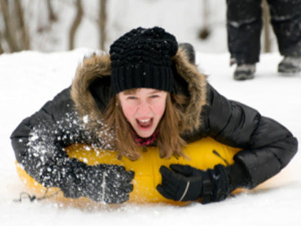 12/23/11 - A Guide to Snow Tubing in the Twin Cities Area – girl in black jacket in yellow tube 