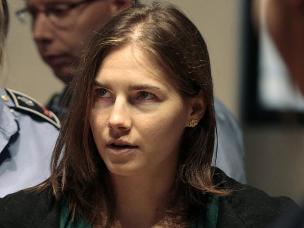 Amanda Knox is escorted as she arrives for an appeal hearing 