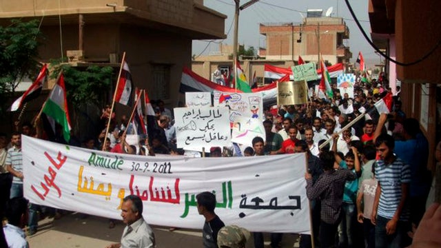 Anti-Syrian President Bashar Assad protesters march at the Kurdish-Syrian village of Amouda 