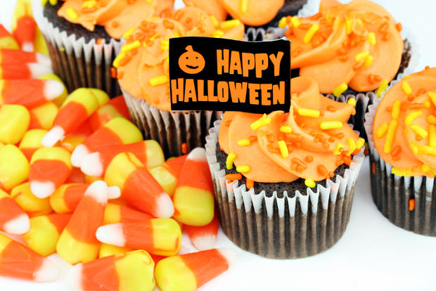 Happy Halloween cupcakes and candy corn on white. 