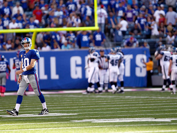 Eli Manning walks to the bench after throwing an interception 