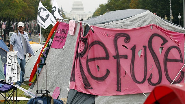 Demonstrators walk through the make-shift tent city as part of the Occupy D.C. demonstration at Freedom Plaza, in Washington on Oct. 11, 2011.  