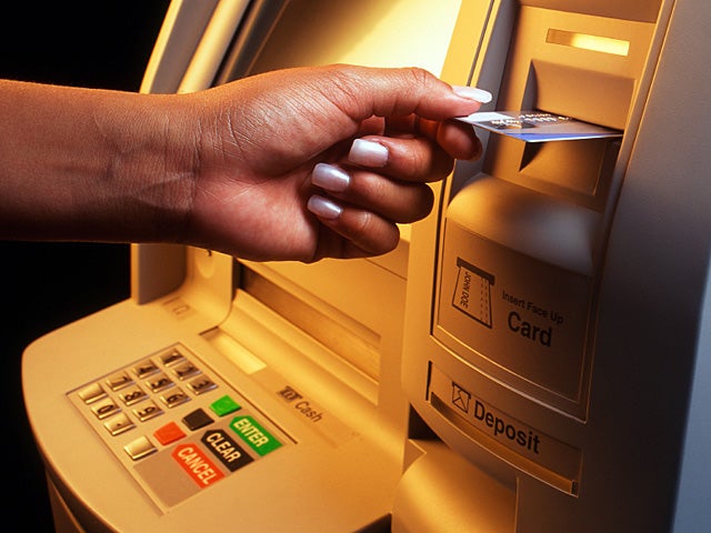 Woman making transaction at ATM machine. 