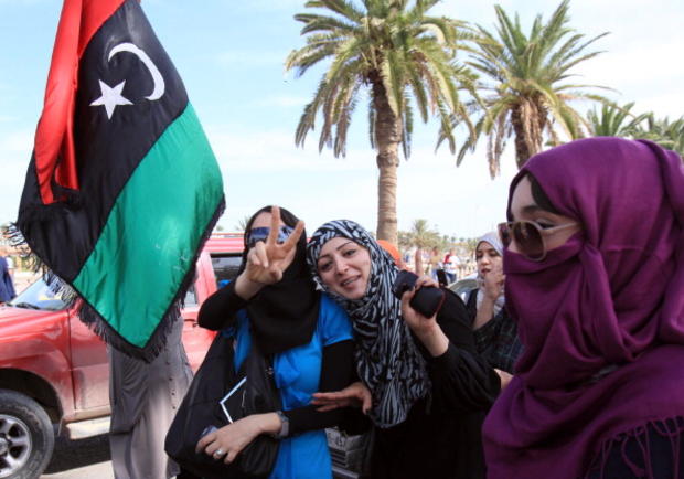Libyans wave their new national flag... 