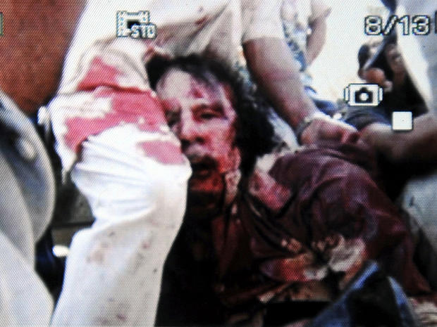 An image captured off a cellular phone camera shows the possible arrest of Libyan strongman Muammar Qaddafi in Sirte, Libya, Oct. 20, 2011. 