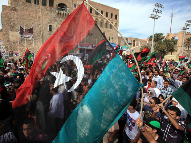 Libyans wave their new national flag as they celebrate 