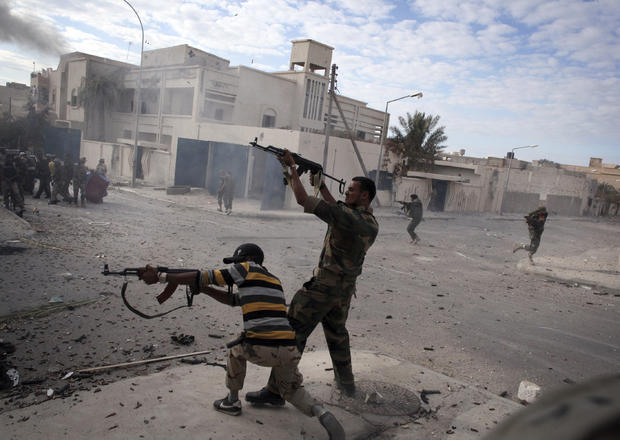 Libyan rebel fighters fire their machine guns  