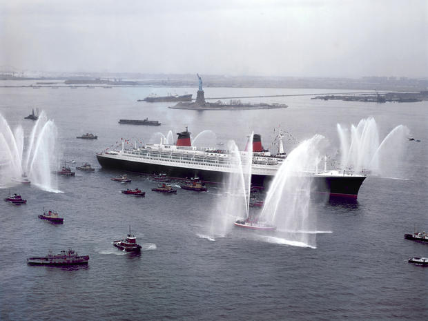 The cruiser Le France is welcomed by U.S. fireboats as she sails past the Statue of Liberty Feb. 8, 1962, into New York Harbor. 