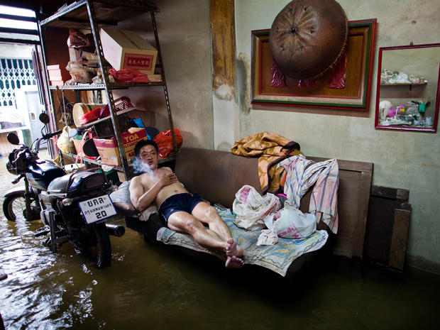 A Thai resident watches television in his flooded home in Chinatown near the overflowing Chao Phraya river Oct. 26, 2011, in Bangkok. Floodwaters are threatening to disrupt Thailand's tourism industry as the country experiences its worst flooding in 50 years. 