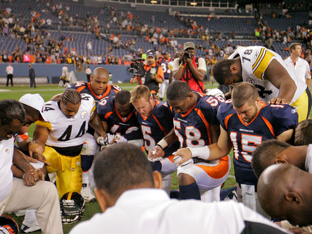 Players from the Steelers and the Broncos kneel in prayer 