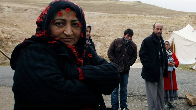 Quake survivor who says she's cold stands outside her tent on outskirts of town center of Ercis, Turkey Thursday 