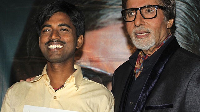 In this Tuesday, Oct. 25, 2011, photograph, Sushil Kumar, left, with Bollywood actor Amitabh Bachchan, shows $1 million check after winning on an Indian game show, in Mumbai, India.  