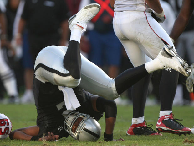 JaMarcus Russell  is hit after throwing the ball  