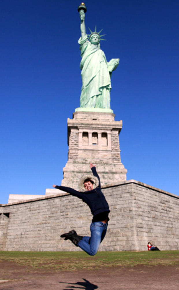 Caroline DuCrey, of Albertville, France, jumps in front of the Statue of Liberty so her friends can take her photo Oct. 28, 2011, the Statue's 125th anniversary. 