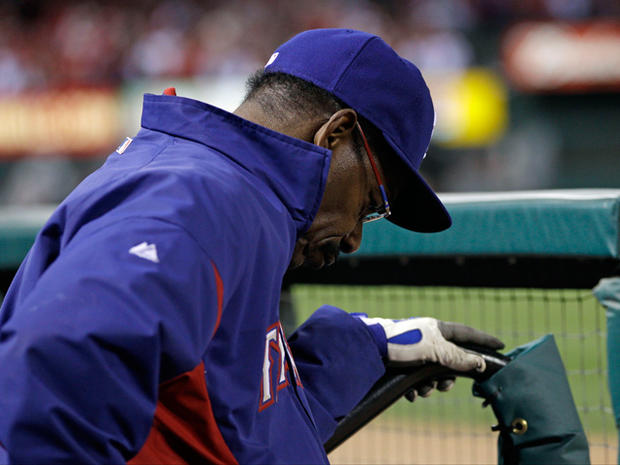 Ron Washington holds his head down in the dugout 