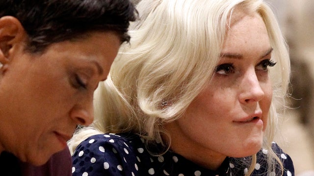 Actress Lindsay Lohan, right, bites her lip as she appears with her attorney Shawn Chapman Holley at a probation hearing in Los Angeles Superior Court Nov. 2, 2011. Judge Stephanie Sautner sentenced Lohan to 30 days in jail and warned the actress there wo 