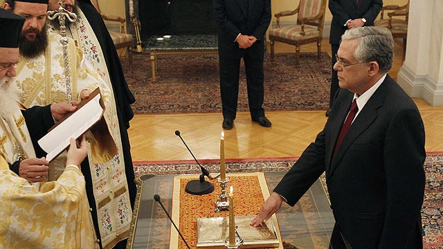 New Prime Minister Lucas Papademos, right, takes the oath of office during the swearing-in ceremony for the new national unity government at the presidential palace in Athens, Nov. 11, 2011.  