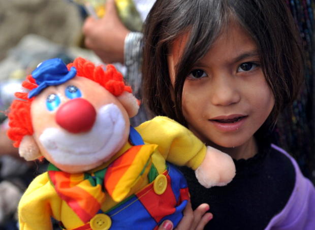 A girl poses with a clown doll... 
