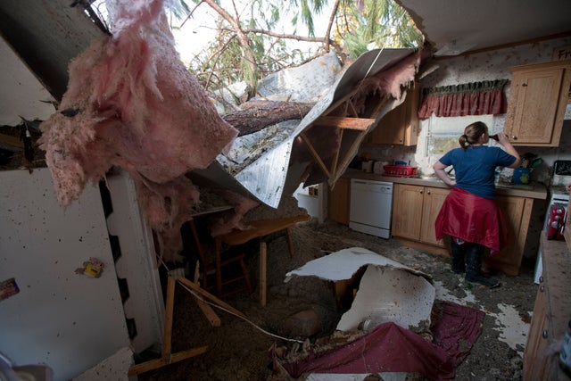 Tabitha Welch drinks a beer as she helps a friend clean up after a windstorm blew several trees into her home 
