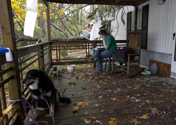 Staci DeGeer sits on her porch and talks with her insurance company  