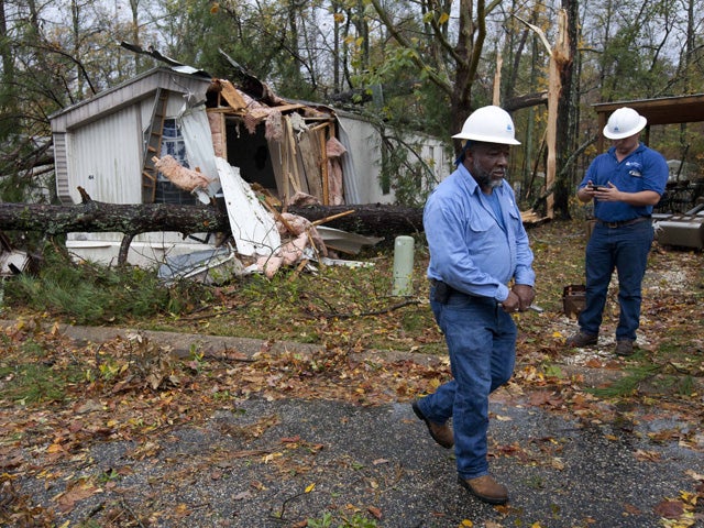Gas company employees go from house to house turning off the gas 
