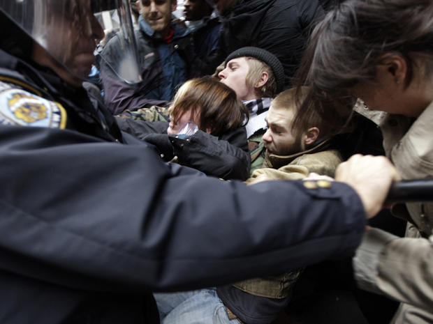Police officers shove demonstrators affiliated with the Occupy Wall Street movement as they block an entrance to the New York Stock Exchange on Broad Street Nov. 17, 2011, in New York. 