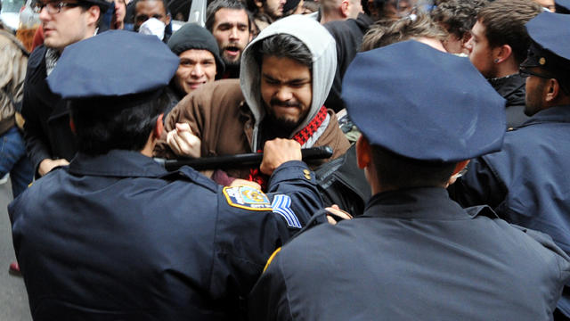 New York Police Department officers push people back as Occupy Wall Street demonstrators converge on Wall Street to mark two months since the movement's birth Nov. 17, 2011. 