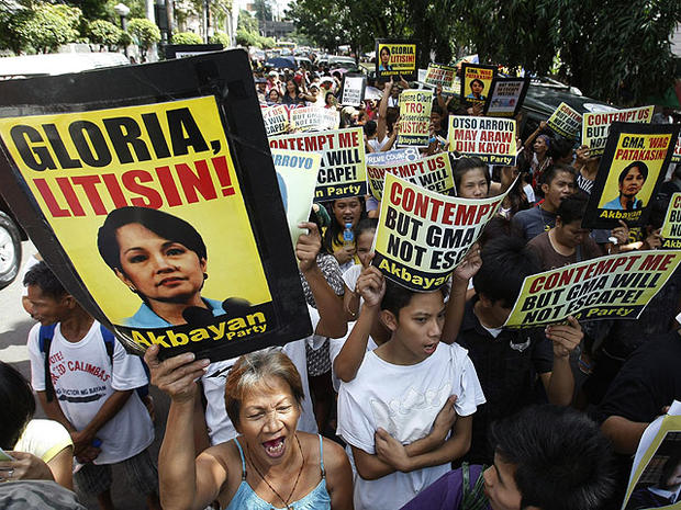 Hundreds of protesters shout slogans and display messages against former Philippine President Gloria Macapagal Arroyo as they march towards the Philippine Supreme Court in Manila, Nov. 18, 2011. 