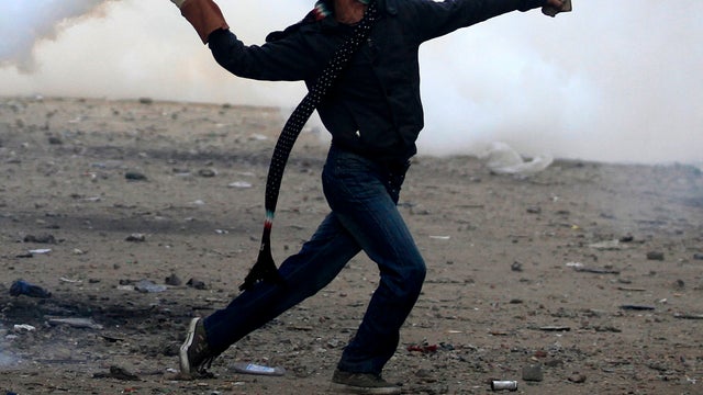 A protester throws a tear gas canister during clashes with Egyptian riot police near Tahrir Square in Cairo Nov. 21, 2011. Security forces fired tear gas and clashed with several thousand protesters in Cairo's Tahrir Square in the third straight day of vi 