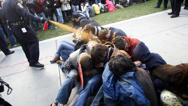 University of California, Davis, Police Lt. John Pike uses pepper spray to move Occupy UC Davis protesters while blocking their exit from the school's quad Nov. 18, 2011, in Davis, Calif. Two officers involved in pepper spraying seated protesters were pla 