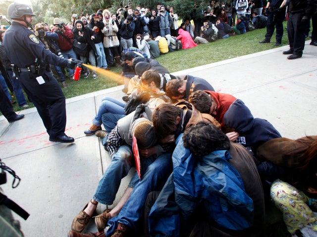 University of California, Davis, Police Lt. John Pike uses pepper spray to move Occupy UC Davis protesters while blocking their exit from the school's quad Nov. 18, 2011, in Davis, Calif. Two officers involved in pepper spraying seated protesters were pla 
