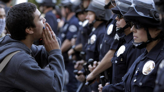 A protester chants slogans in front of police officers during a rally in Los Angeles Nov. 17, 2011. Occupy Wall Street demonstrators held modestly sized but energetic rallies around the country to celebrate two months since the movement's birth and to sig 