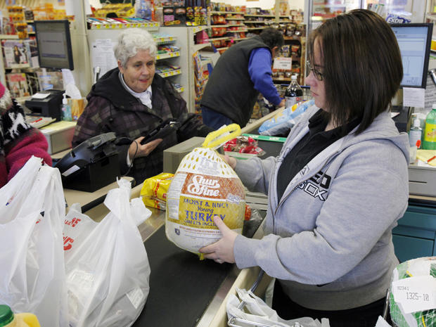 A clerk bags a turkey for a customer  
