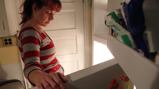 Jackie Galinis stares into her refrigerator and freezer 