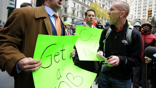 Occupy Wall Street demonstrator David Suker, right, argues with counter-demonstrator Derrick Tabacco, left, a small business owner, near the New York Stock Exchange as the Occupy movement marks two months since its birth Nov. 17, 2011, in New York. 
