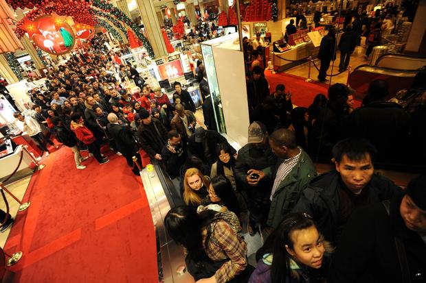 A crowd lines up to get on an escalator inside Macy's 