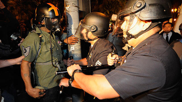Los Angeles Police Officers in riot gear push Occupy L.A. demonstrators back on the sidewalk in an attempt to clear the streets around Los Angeles City Hall after the deadline to dismantle the occupy campsite expired on November 28, 2011.  