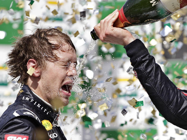 Mark Webbe pours champagne on teammate Sebastian Vettel 
