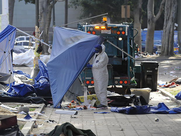 Los Angeles City sanitation workers clean up the aftermath of the Occupy Los Angeles after police broke up the large encampment of protesters who had been camping out for the past two months at City Hall, Nov. 30, 2011.  