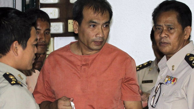 Joe Gordon is escorted by correction officials at a criminal court in Bangkok 