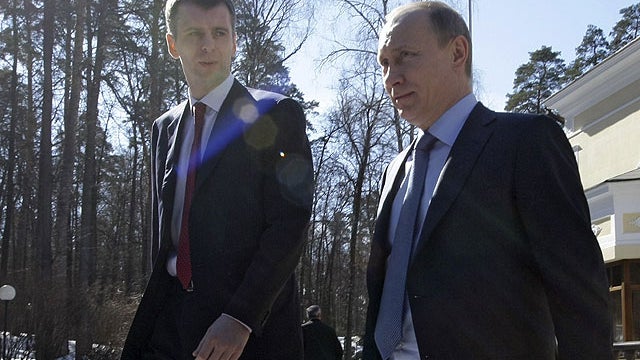 In this April 1, 2011 file photo, Russian Prime Minister Vladimir Putin, right, flanked by Russian billionaire Mikhail Prokhorov, goes to inspect a new Russian-designed hybrid cars called "Yo" at the Gorki residence outside Moscow, Russia.  